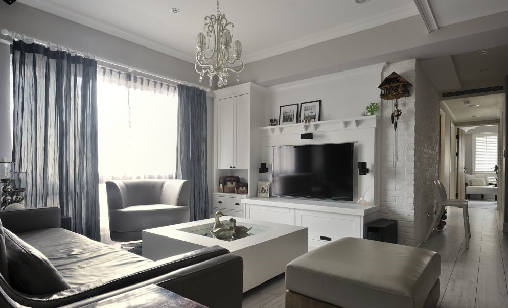 白色作為一個經典舒適的顏色，搭配在客廳電視櫃設計之中，結合簡約大氣的系統櫃與沙發佈置，可以營造出一種情趣愜意的客廳氛圍