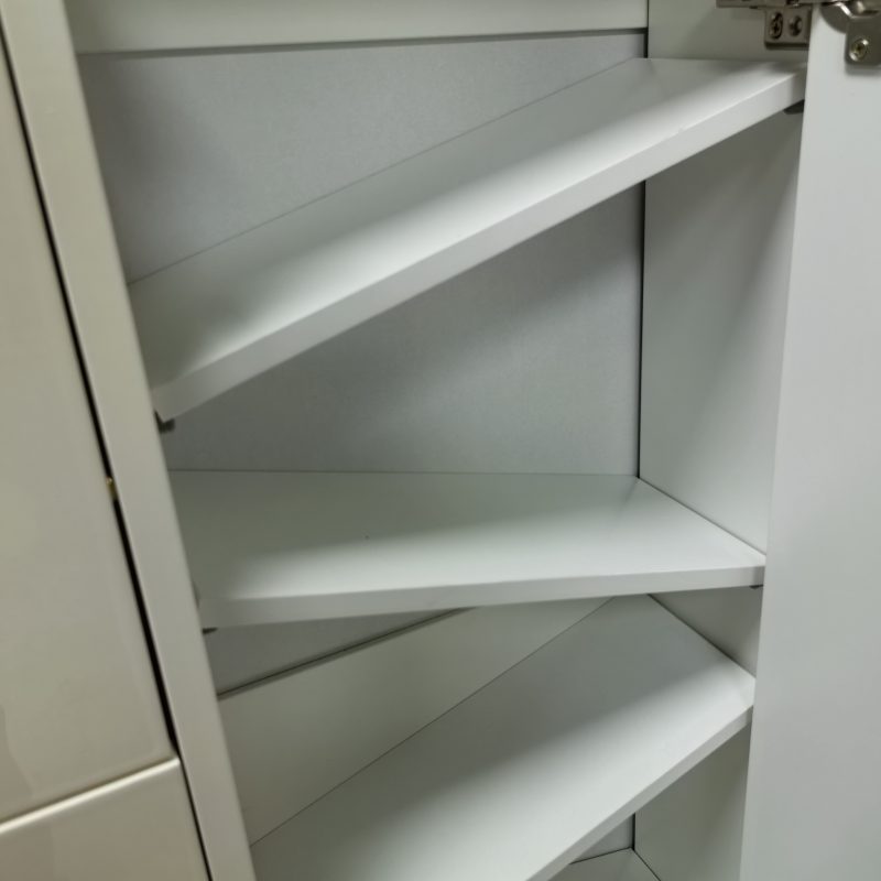 Caleb 鞋櫃翻斗內部近拍，米白櫃身內三層向前斜放嘅白色層板，右上角見不鏽鋼液壓鉸位，用作翻斗打開時擺放鞋履。