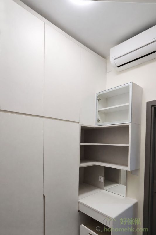 衣帽間以淺灰色櫃體為主，搭配玻璃門設計，提升通透感之餘，也方便展示香水及飾物等精品。內部布局合理，將掛衣區與儲物格巧妙結合，讓空間利用率達到最高，滿足日常收納需求之餘，還保有高質感的視覺效果。