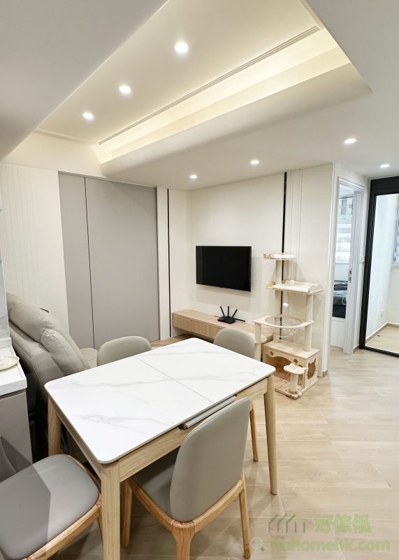 客廳的天花設計以高低層次為主，增添空間感與視覺層次，軌道燈的應用則讓日常生活更添靈活性。燈光位置可隨時調整，將來也可以更換不同的燈組，無論是聚焦於餐桌、梳化區，都能輕鬆實現。