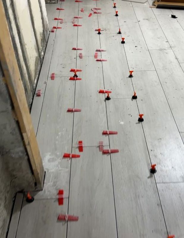 北角城市花園泥水工程 — 客廳及房間鋪木紋磚 (亂工鋪) 施工進行中，準備上掃口粉前。