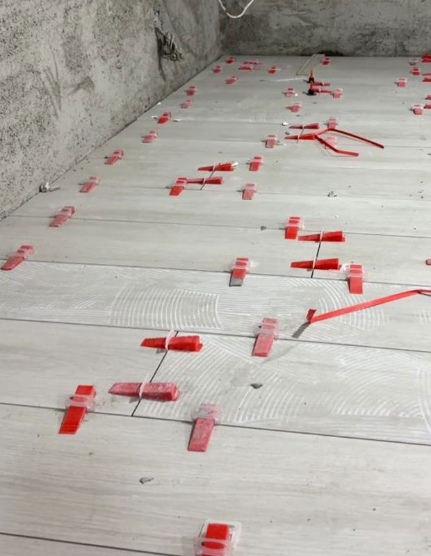 北角城市花園泥水工程 — 客廳及房間鋪木紋磚 (亂工鋪) 施工進行中，準備上掃口粉前。