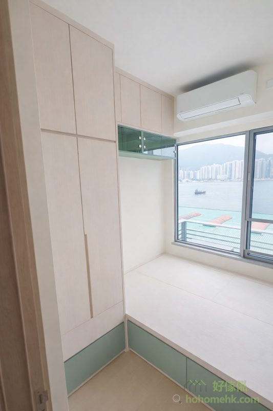 望海的單位，最適合配合湖水綠及藍綠色的訂造傢俬設計，將窗外的海天美景引入室內。這次案例中，地台床、衣櫃及梳化皆融入了湖水綠元素，不僅延續了室外的自然感，更帶來一種清新而寧靜的視覺體驗，讓整個居住空間更具統一感與格調。