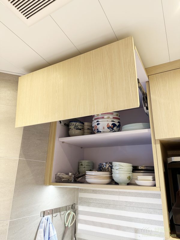吊櫃的設計同樣考慮到實用性和安全性，採用了上翻門設計，開門時不會撞到頭，使用更加方便。同時，吊櫃內部空間充足，可以存放碗碟、乾糧等日常用品，令廚房保持整潔。這樣的設計不僅解決了空間利用問題，更提升了居家生活的便利性。