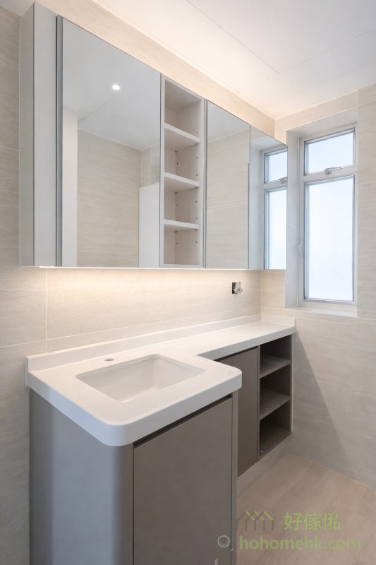 客廳以白色為主調，配搭少量玻璃櫃和深灰色地櫃，整體設計簡約而不失層次感。白色提升了空間感，而深灰和玻璃材質的點綴，則為空間增添了現代感，讓客廳成為全家人共享的舒適空間。