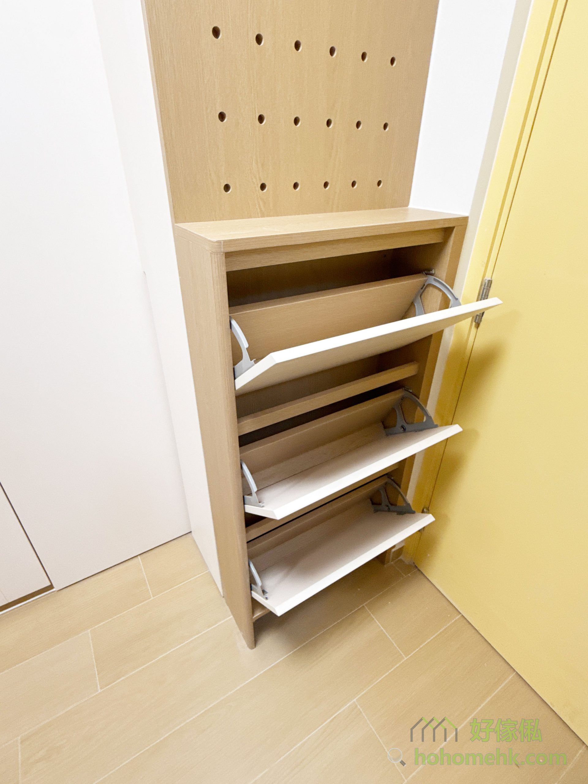 間房對面,在入門旁訂造了一個小鞋櫃,善用空間設置多功能收納區,翻摺式鞋櫃既能節省地面空間,又便於日常生活取用。而枱面就手的高度亦方便放置信件和鎖匙等小物件,而上方更訂造了同色洞洞板,掛外套、手袋,甚至各類飾品都OK,不論是家庭雜物、鞋類或小型飾品,都能找到專屬的收納位置,保持客廳與間房的整潔與條理。