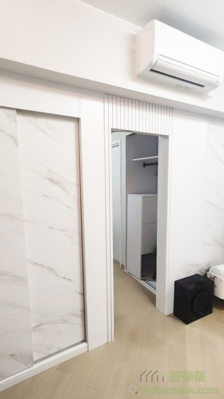 以背景牆完美融入隱形門，除了提升空間一體性外，還隱藏了房門及儲物櫃，令視線更加純粹。此設計大大提升空間利用率，尤其適合香港的中小型住宅，讓每一吋空間顯得井井有條。