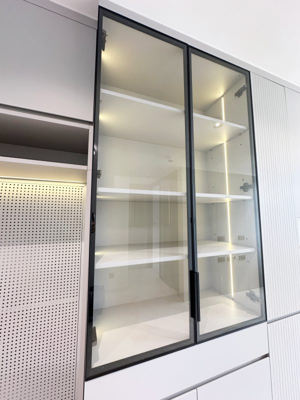 客廳櫃內結合了一組玻璃飾櫃，既適合擺放裝飾品，又賦予整體空間輕盈感。櫃內的內置燈帶進一步凸顯展示效果，令空間更富有層次感，實現了美觀與實用的雙贏。