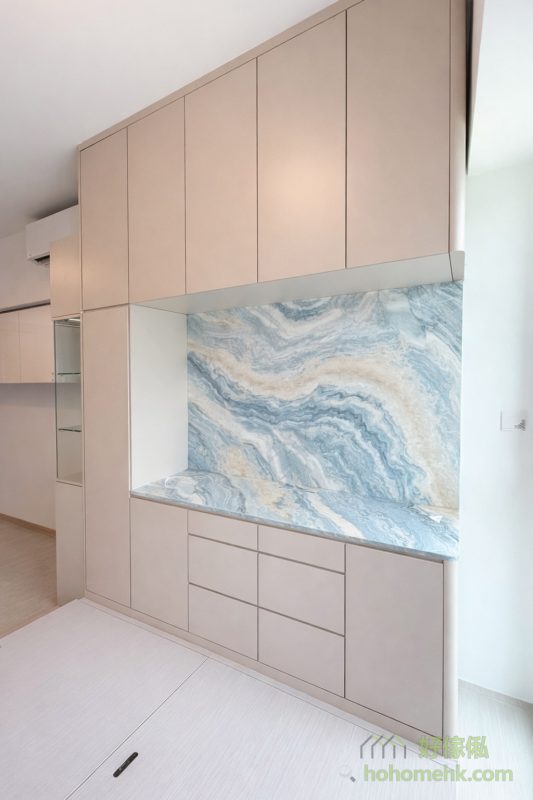 採用奶茶色調的櫃身設計，可以高效反射自然光與燈光，尤其適合深長型客廳，令室內更顯明亮光猛。局部加入藝術紋理的設計，例如訂造的油畫風格的飾面，不僅提升空間的高級感，還加強了整體的藝術氣息，讓家居更具品味。